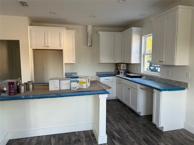 a kitchen with kitchen island granite countertop a sink a stove and cabinets