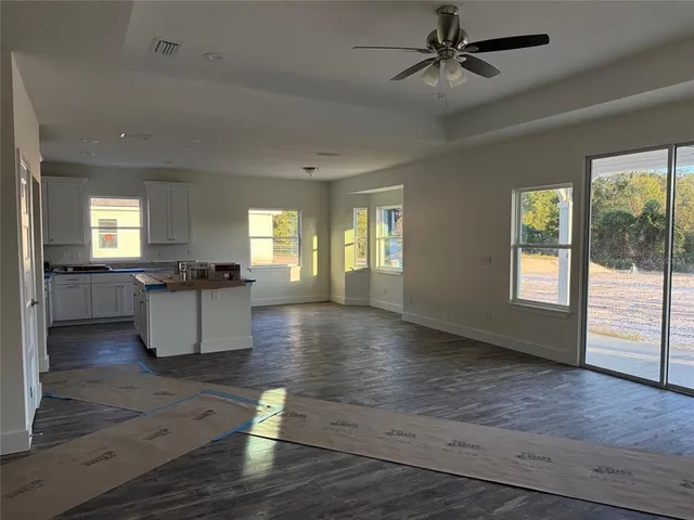 a view of an empty room and window with wooden floor