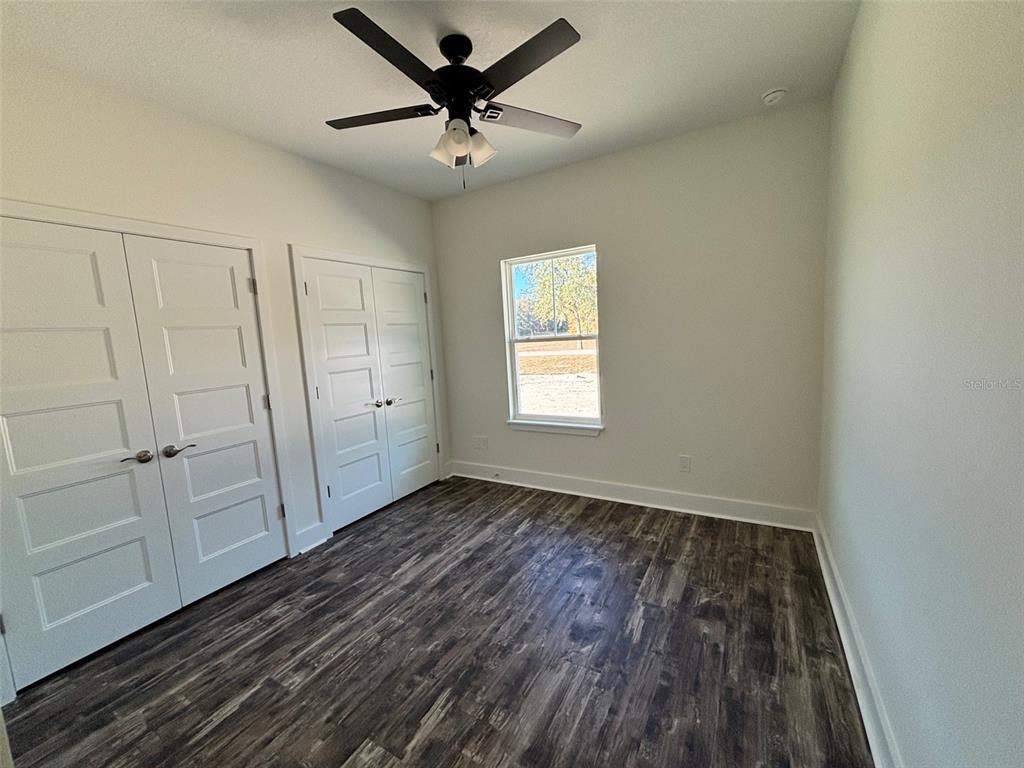 5949 South E County Road 21B Keystone Heights, FL 32656 - Photo 20 of 30 an empty room with wooden floor fan and windows