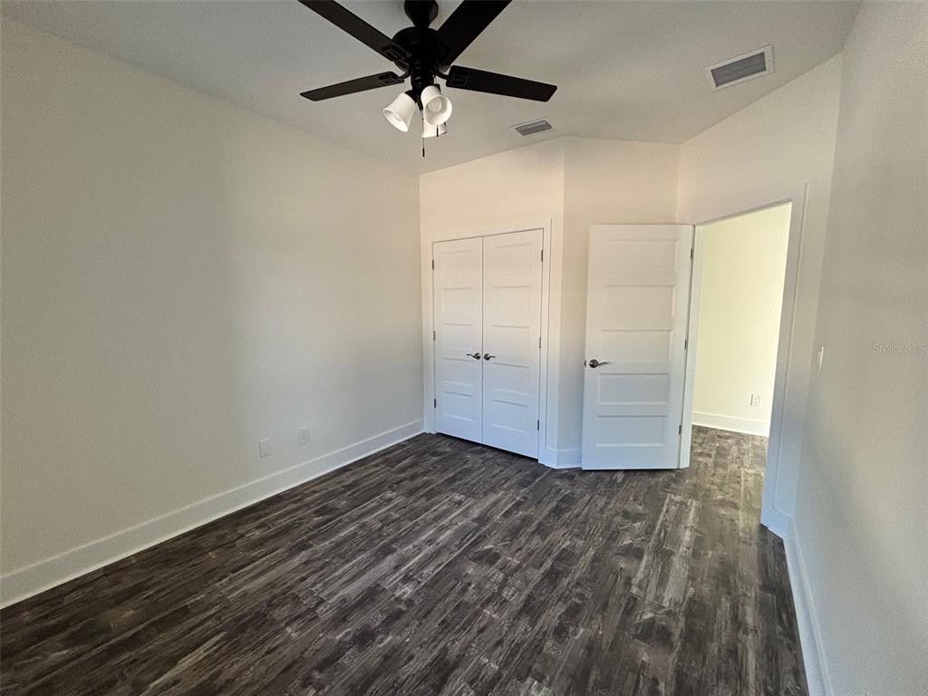 5949 South E County Road 21B Keystone Heights, FL 32656 - Photo 23 of 30 an empty room with wooden floor fan and windows