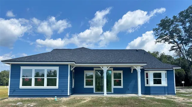 a view of a brick house with large windows and a large tree
