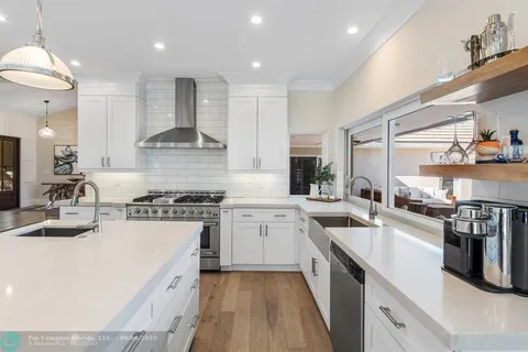a kitchen with stainless steel appliances a sink stove and cabinets