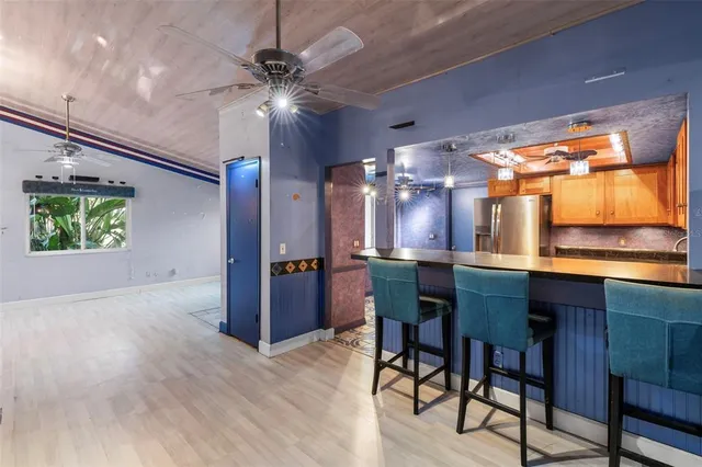 a kitchen with stainless steel appliances kitchen island granite countertop a table chairs and a window