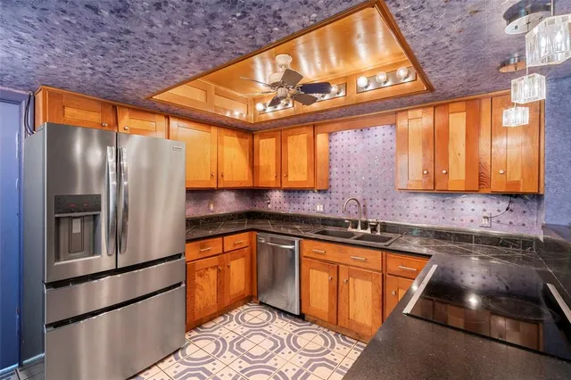 a kitchen with stainless steel appliances granite countertop a refrigerator and a sink