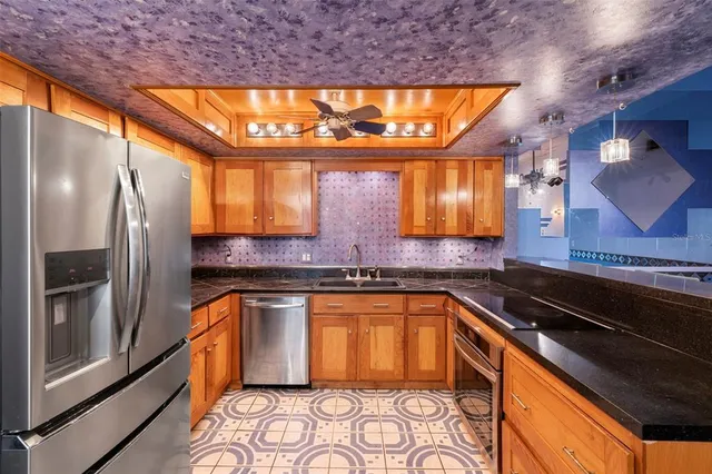 a kitchen with stainless steel appliances granite countertop a sink and a refrigerator