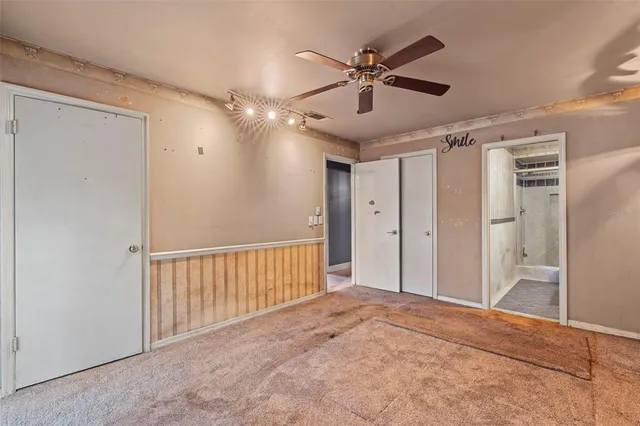 a view of a hallway with a chandelier fan
