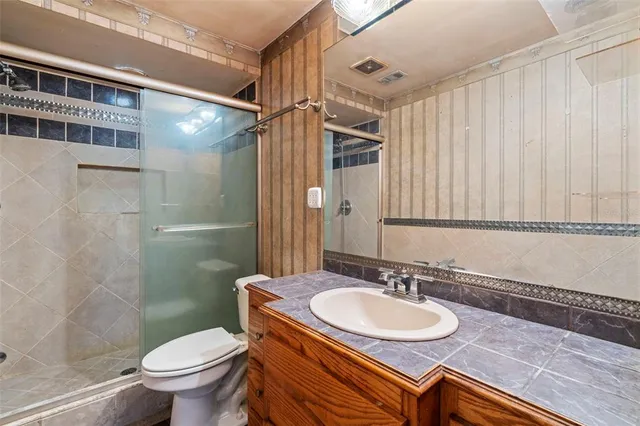 a bathroom with a sink toilet a mirror and shower