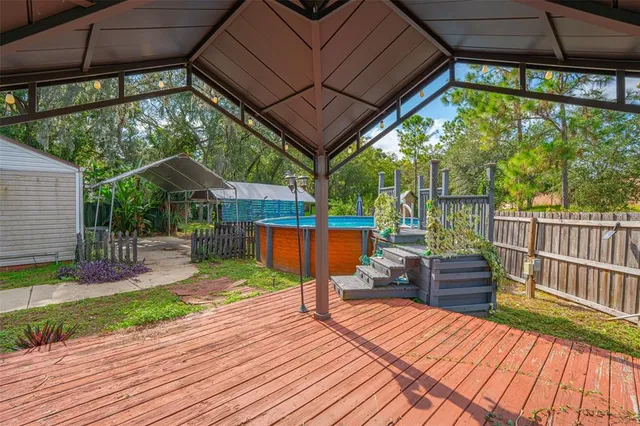 a view of a backyard with swimming pool and sitting area