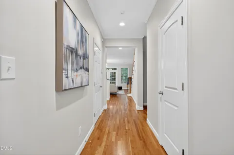 a view of a hallway with wooden floor and staircase