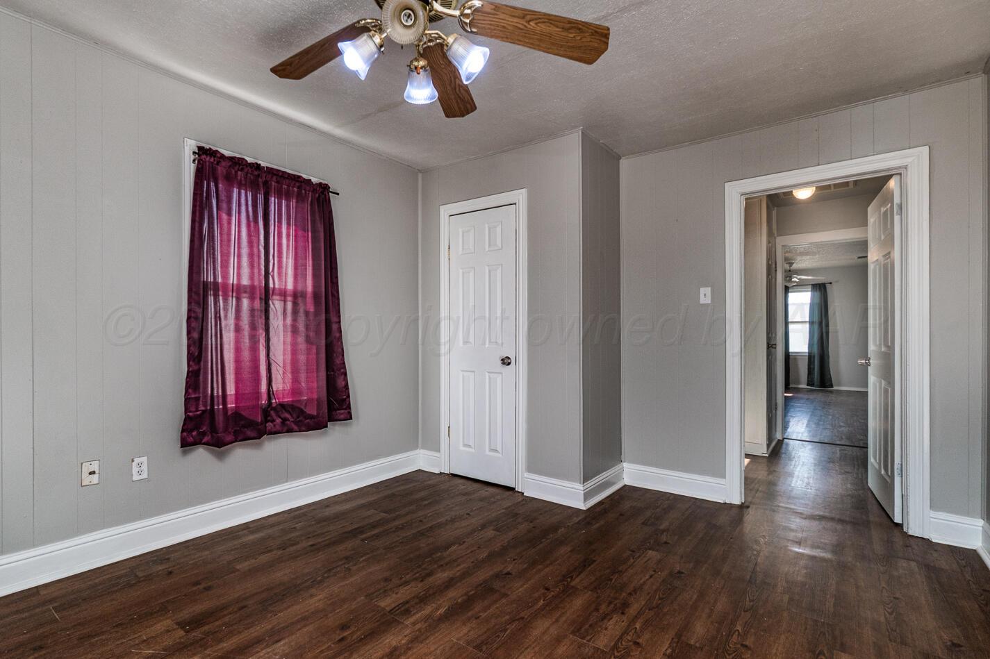 8015 Upton Road Amarillo, TX 79119 - Photo 15 of 16 a view of a room with wooden floor wooden floor and a chandelier