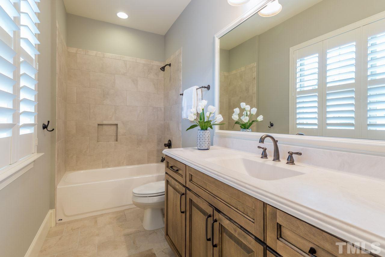 5011 Pomfret Point Raleigh, NC 27612 - Photo 15 of 25 Features include cultured marble counter top with rectangular sink, tub/shower combination with tile surround, framed mirror, ceramic tile floor, and plantation shutters.