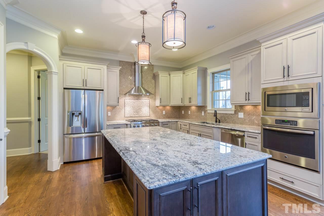 5011 Pomfret Point Raleigh, NC 27612 - Photo 6 of 25 Imagine the joy you'll experience while preparing meals for casual dining & entertaining in this gorgeous kitchen! Features include a large central kitchen island with double pendant lights,gas range w/range hood, refrigerator,and stainless appliances.