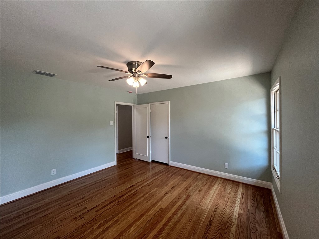 353 Jackson Place Corpus Christi, TX 78411 - Photo 12 of 24 an empty room with wooden floor chandelier fan and windows