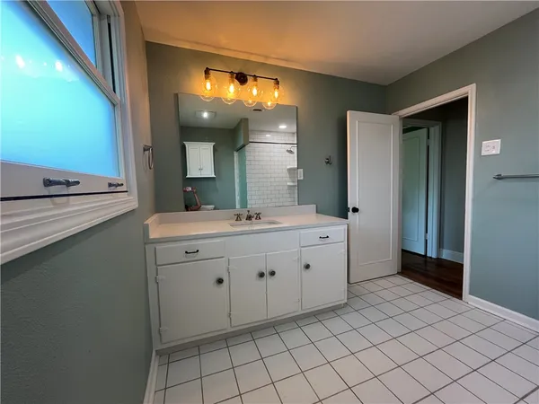 a bathroom with a sink vanity and mirror