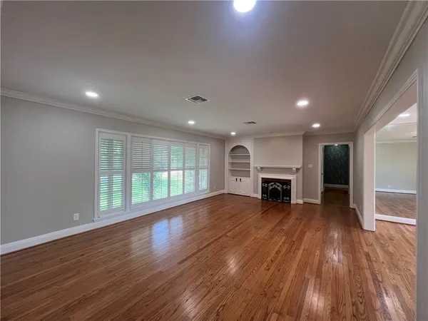 a view of empty room with wooden floor and fireplace