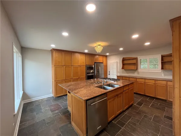 a kitchen that has a sink a stove and a table in it