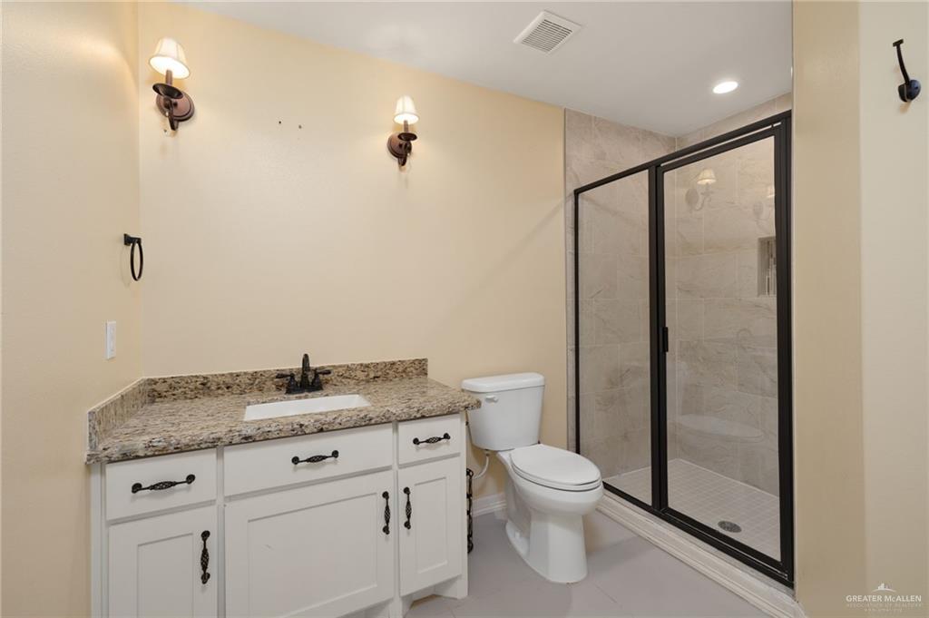 501 Olmo Street Mission, TX 78572 - Photo 11 of 17 a bathroom with a granite countertop sink toilet and shower
