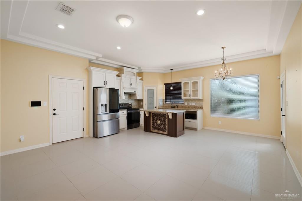 501 Olmo Street Mission, TX 78572 - Photo 3 of 17 a kitchen with stainless steel appliances a refrigerator and a stove top oven