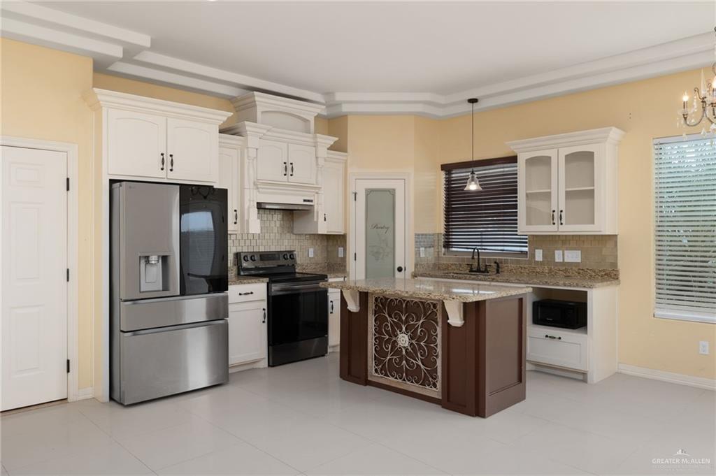 501 Olmo Street Mission, TX 78572 - Photo 4 of 17 a kitchen with stainless steel appliances granite countertop a stove a refrigerator and a refrigerator