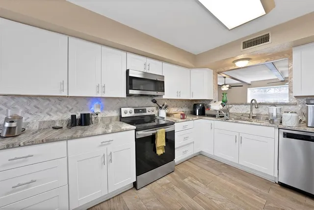 a kitchen with granite countertop a refrigerator and a sink