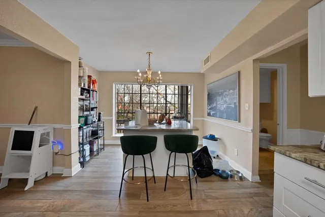 a dining room with furniture a chandelier and wooden floor