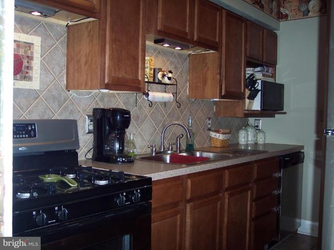 126 Malbrook Road Baltimore, MD 21229 - Photo 14 of 20 a kitchen with stainless steel appliances granite countertop a sink stove and cabinets
