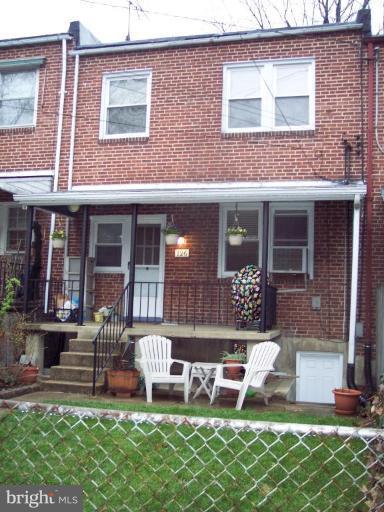 126 Malbrook Road Baltimore, MD 21229 - Photo 18 of 20 a view of a brick house with a yard chair and a table
