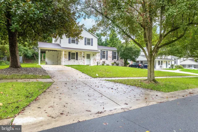 a front view of a house with a garden and trees