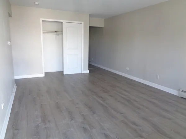 a view of an empty room with wooden floor