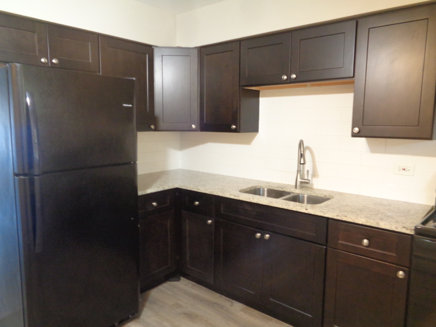1340 North Main Street, Unit A12 Wheaton, IL 60187 - Photo 3 of 8 a kitchen with a sink and refrigerator