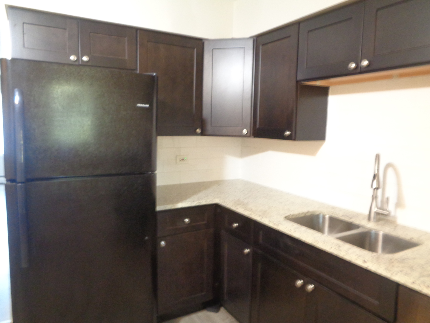 1340 North Main Street, Unit A12 Wheaton, IL 60187 - Photo 4 of 8 a kitchen with a sink and a refrigerator