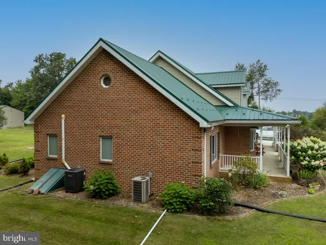 a view of a dining room with furniture a chandelier and large windows