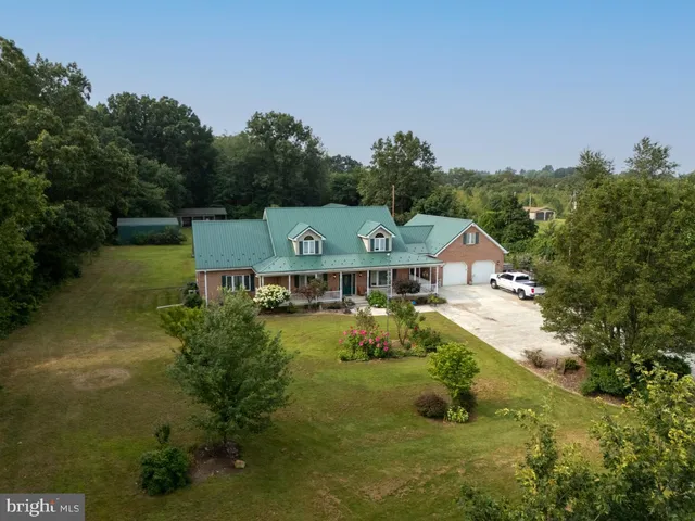 an aerial view of a house with a garden and lake view