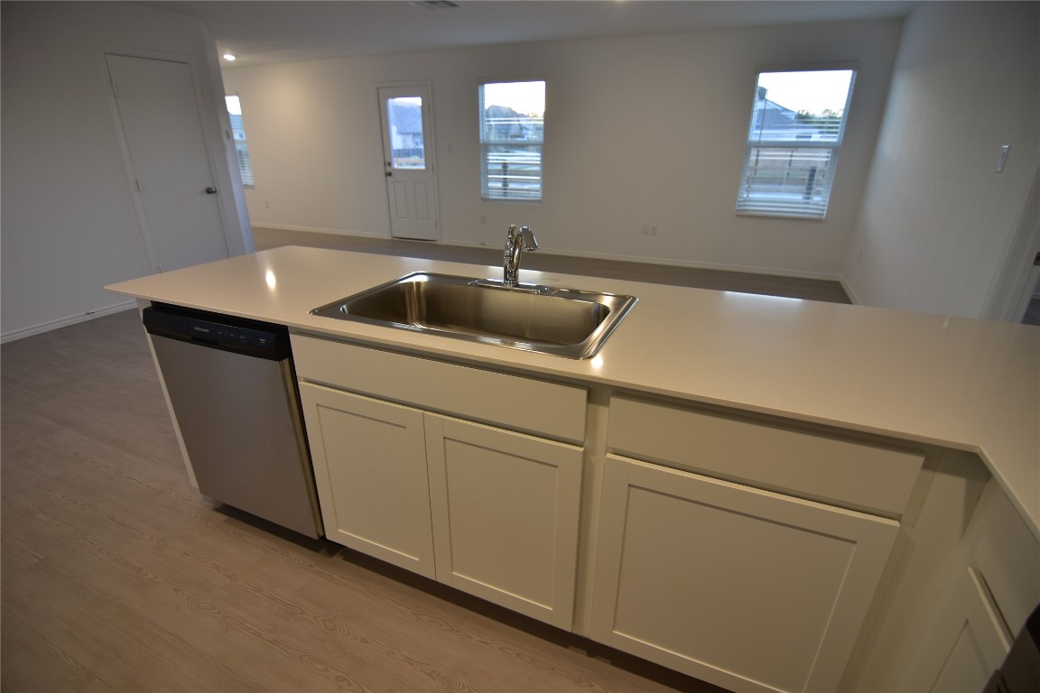 343 Keefer Kyle, TX 78640 - Photo 13 of 38 Kitchen with white cabinets, light wood finished floors, light countertops, and dishwasher