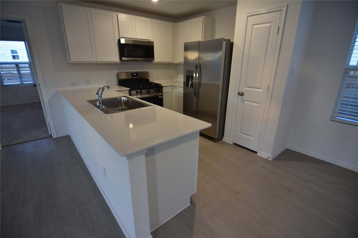 343 Keefer Kyle, TX 78640 - Photo 16 of 38 Kitchen with stainless steel appliances, white cabinetry, light countertops, and light wood-type flooring