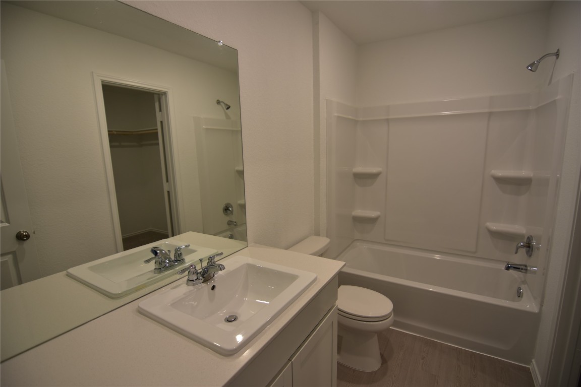 343 Keefer Kyle, TX 78640 - Photo 30 of 38 Bathroom featuring shower / bath combination, vanity, dark wood-style floors, and a walk in closet