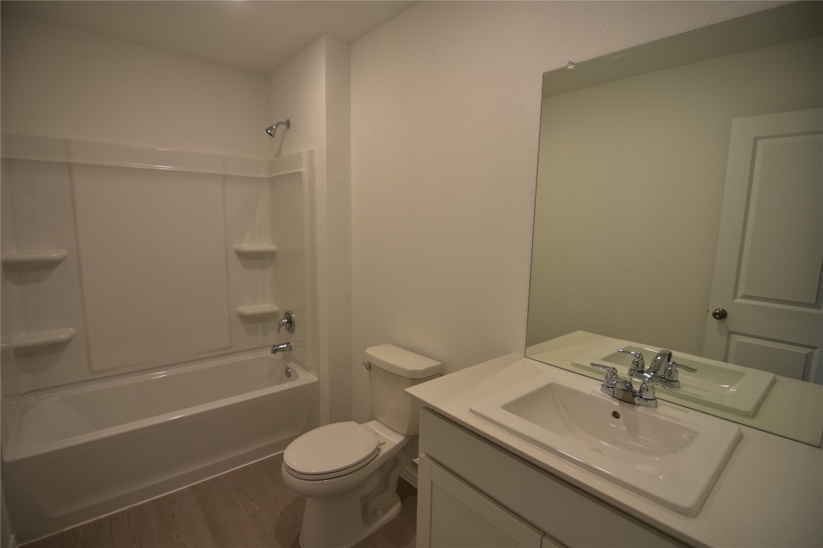 343 Keefer Kyle, TX 78640 - Photo 37 of 38 Bathroom with washtub / shower combination, dark wood-style floors, and vanity