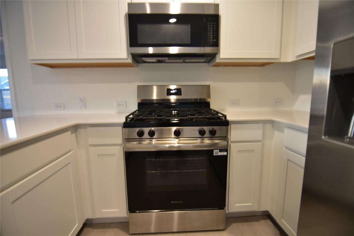343 Keefer Kyle, TX 78640 - Photo 5 of 38 Kitchen with appliances with stainless steel finishes, white cabinetry, and light countertops