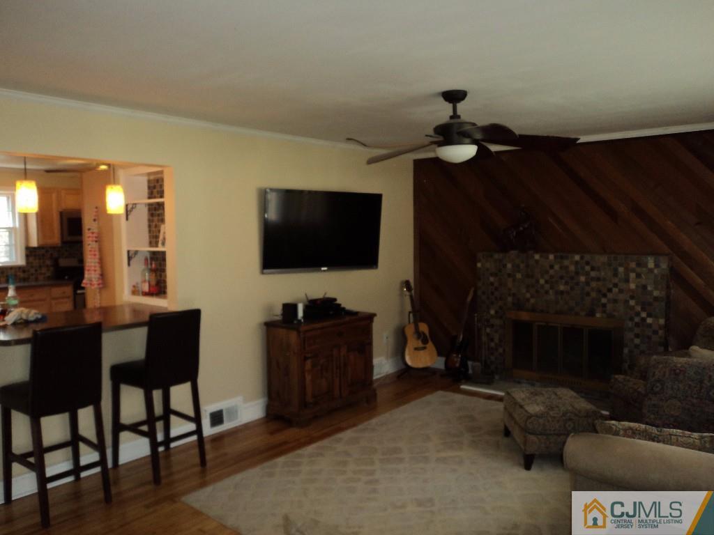 515 Sutherland Road Ewing, NJ 08618 - Photo 3 of 25 a living room with furniture a flat screen tv and a fireplace