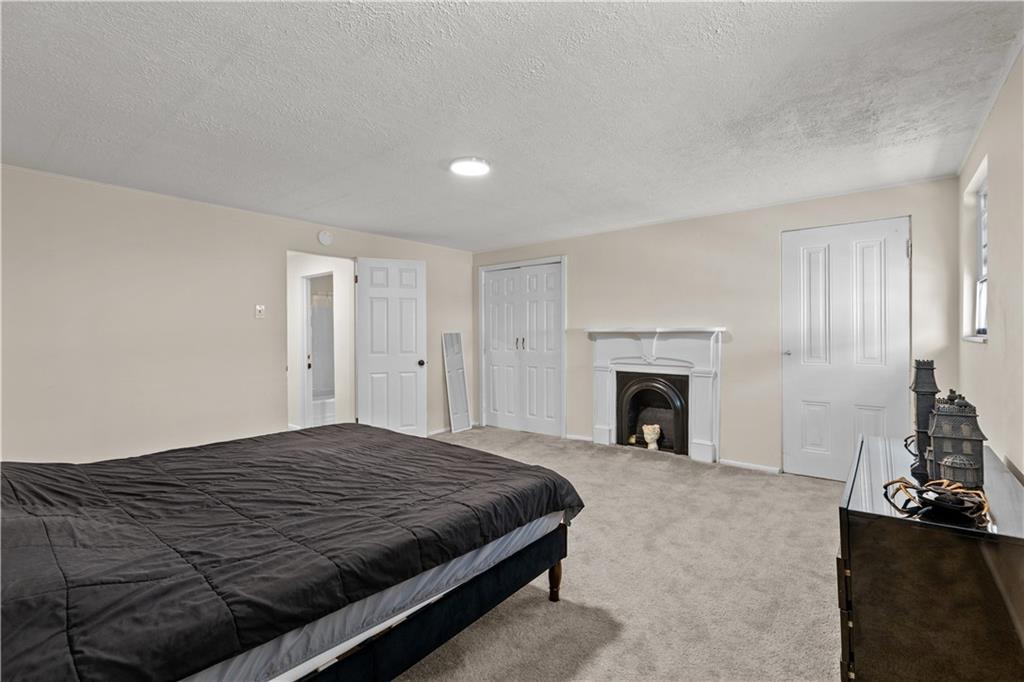 115 Frederick Street Mount Oliver, PA 15210 - Photo 13 of 35 a spacious bedroom with a bed and a fireplace