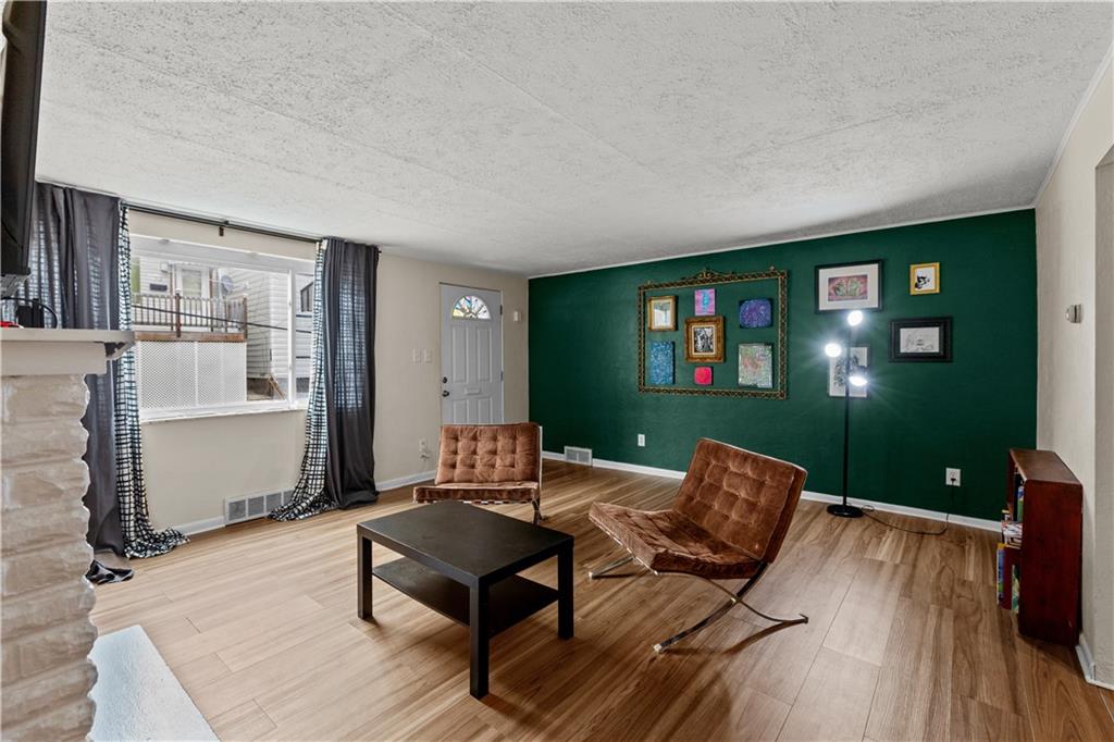115 Frederick Street Mount Oliver, PA 15210 - Photo 3 of 35 a living room with furniture a lamp wooden floor and a large window