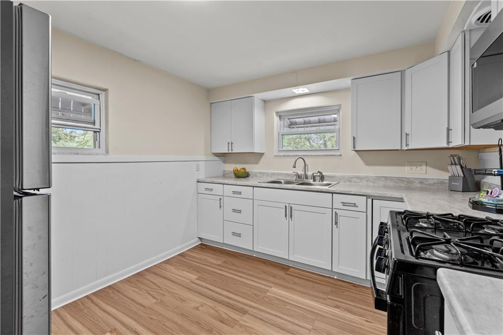 115 Frederick Street Mount Oliver, PA 15210 - Photo 7 of 35 a kitchen with granite countertop cabinets stainless steel appliances and a wooden floor