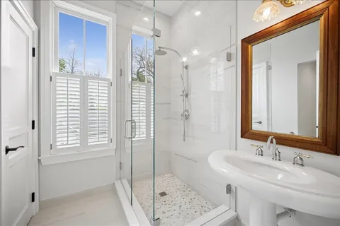 a bathroom with a sink a toilet and shower