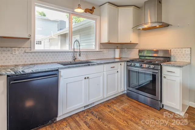 a kitchen with granite countertop a sink stainless steel appliances and cabinets
