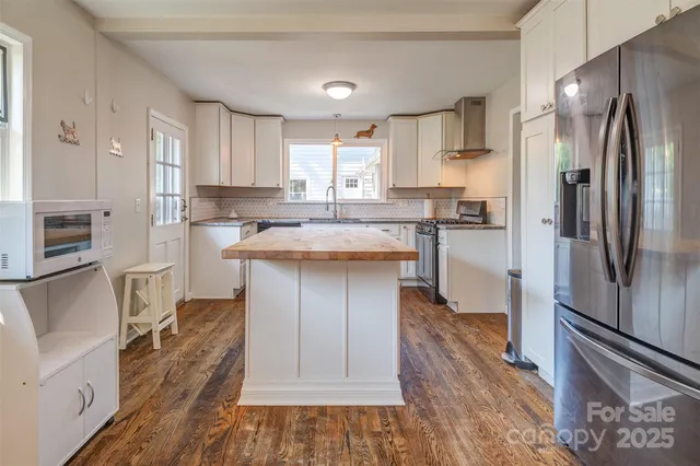 a kitchen with stainless steel appliances granite countertop a refrigerator a stove and a sink