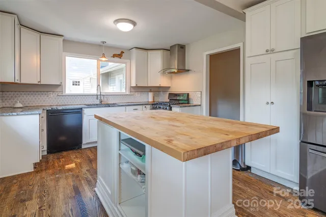 a kitchen with stainless steel appliances granite countertop a sink and a refrigerator
