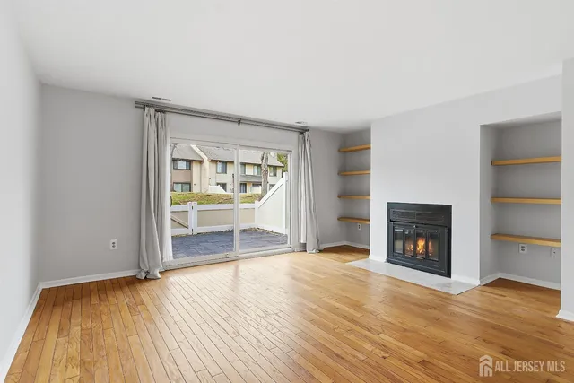 a view of an empty room with a fireplace and a window