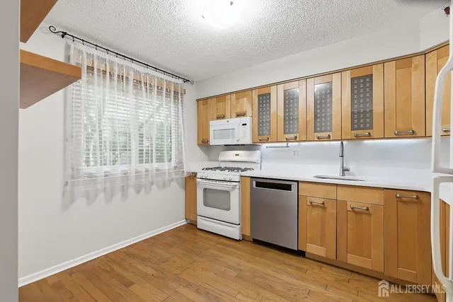 a kitchen with stainless steel appliances granite countertop a sink and wooden cabinets