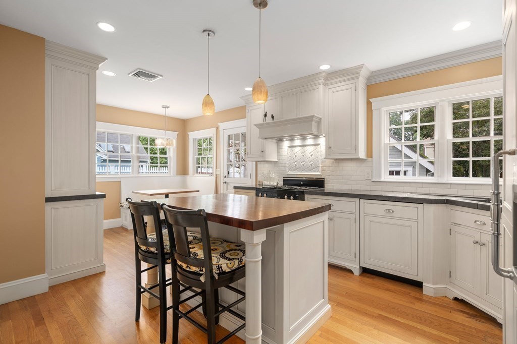 66 Stevens Road Needham, MA 02492 - Photo 6 of 33 a kitchen with stainless steel appliances granite countertop a kitchen island a stove a table and a refrigerator