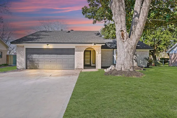 a front view of a house with a garden and yard